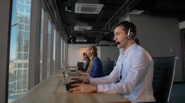 Çekici iş kişi ofis çağrı merkezi müşteri ile konuşmak ve sonra kameraya gülümse