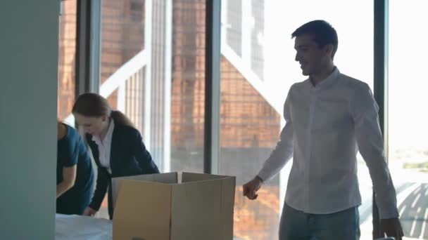 Geschäftsleute packen Kisten aus und betrachten Straßenzeichnungen im modernen Büro. — Stockvideo