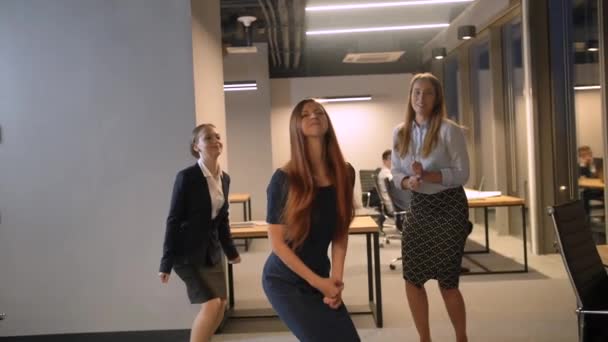 Trois femmes d'affaires sautant heureux célébrant le succès dans le centre de coworking moderne, équipe acclamant avec succès le mouvement lent 