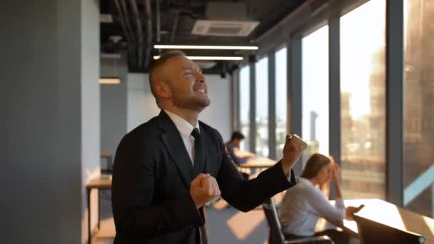Jefe Empresario bailando por la ventana en la oficina durante el atardecer — Vídeos de Stock