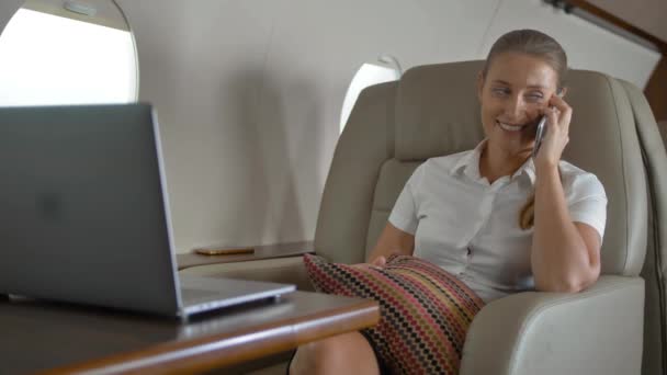 Щаслива бізнес-леді розповідає про розкішну подорож всередині маленьких приватних літаків — стокове відео