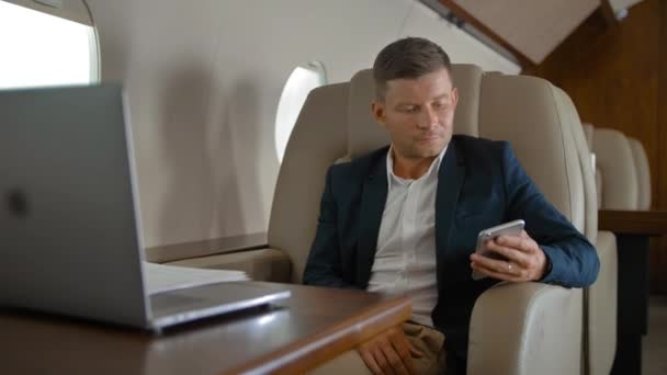 Businessman chatting sitting in comfortable armchair in private jet cabin — Stock Video