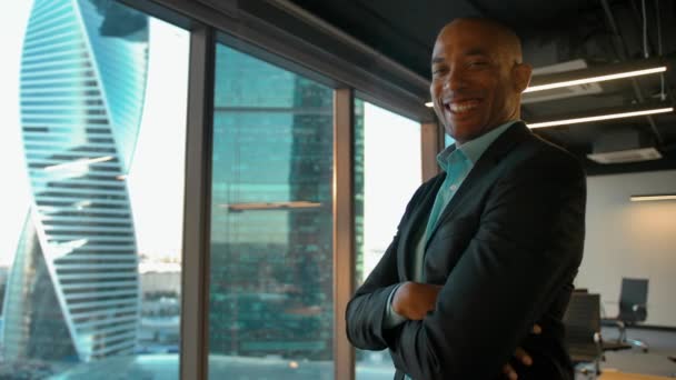 African american boss standing near huge modern office window and smiles. — Stock Video