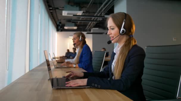 Call center mujer de negocios tener conversación con los clientes y mirando a la cámara — Vídeo de stock