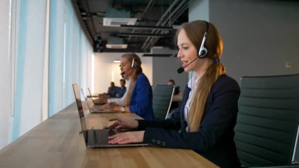 Call center mulher de negócios ter conversa com os clientes e olhando para a câmera — Vídeo de Stock