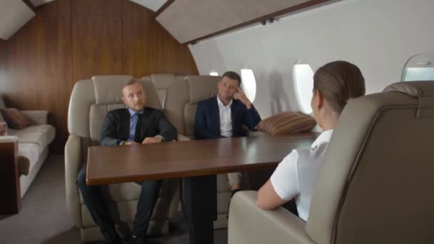 Dos empresarios masculinos seguros y una empresaria exitosa dentro del avión aéreo — Vídeo de stock