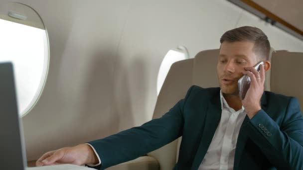 携帯電話のパートナー接続航空機ジェット旅行で話すビジネスマン — ストック動画