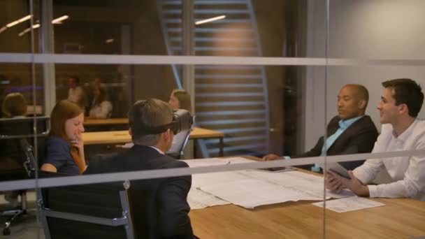 男は仮想現実で、テーブルに座ってビジネス チームはゴーグルします。オフィスでのミーティングで vr のヘッドセットをテストする人. — ストック動画