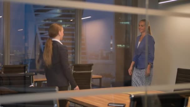 Две сотрудницы-женщины пожимают руку в современном офисе — стоковое видео