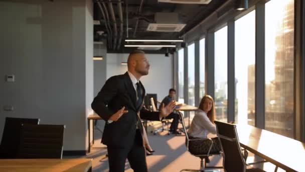 Patron danse fou par la fenêtre dans le bureau pendant le coucher du soleil — Video