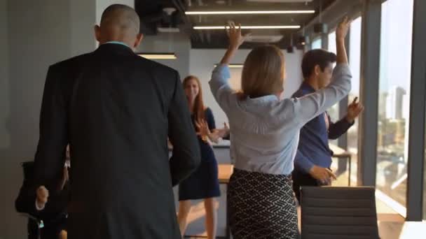 Atractivos empresarios seguros bailando alegremente en la oficina delante de la cámara — Vídeo de stock