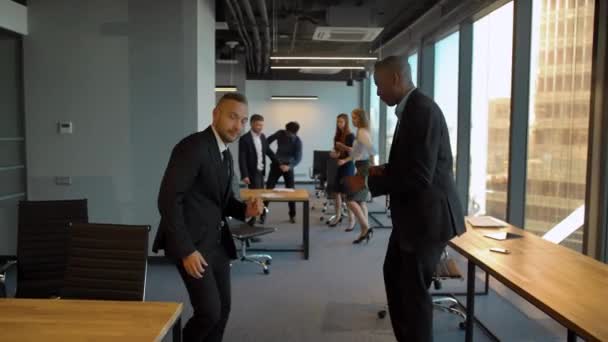 Empleados caucásicos y aframericanos bailando en la oficina de coworking — Vídeo de stock