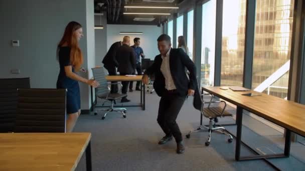 Hombre guapo y mujer sexy en la oficina de negocios bailando después de ganar acuerdo celebrando — Vídeo de stock