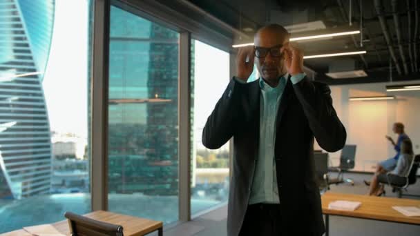 Joven emprendedor afroamericano masculino poniéndose gafas y mirando a la cámara — Vídeos de Stock
