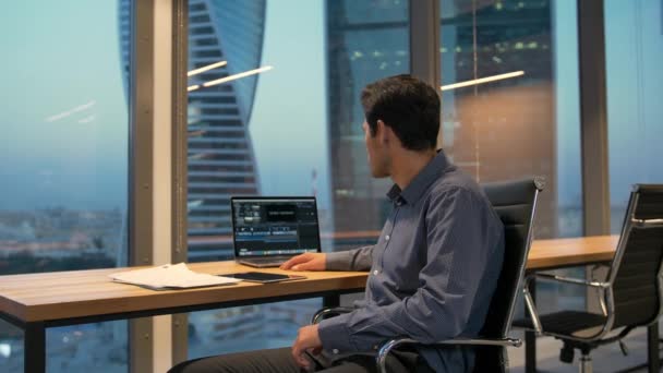 Un angajat hispanic stând în fotoliu cu laptop în birou de afaceri — Videoclip de stoc