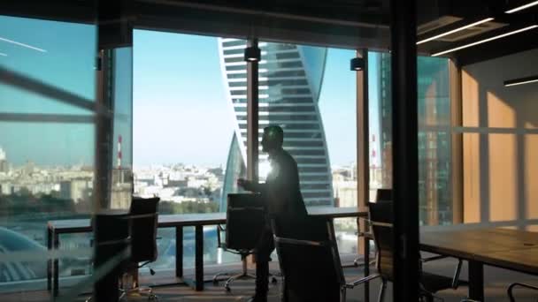 Силуэт "Один танцующий работник" в современном бизнес-офисе со стеклянной стеной и дверью — стоковое видео