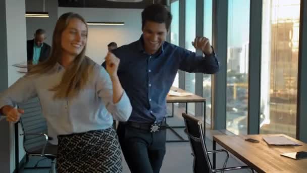 Привлекательные уверенные коллеги празднуют с танцами в своем офисе . — стоковое видео