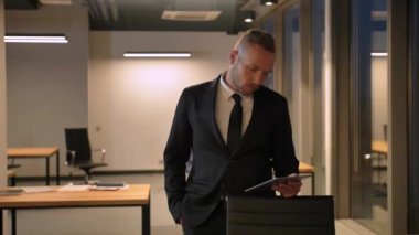 Akşam iş merkezinde Tablet PC bakarak Genç adam.