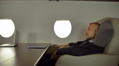 Yorgun iş adamları uçakta uyuyor.