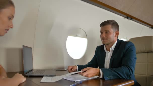 Empresarios dentro del moderno jet privado de lujo firmando documentos importantes — Vídeos de Stock