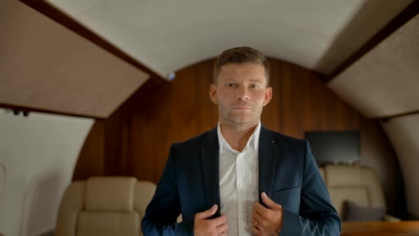 Портрет богатого улыбающегося предпринимателя внутри его собственного бизнес-салона самолета — стоковое видео