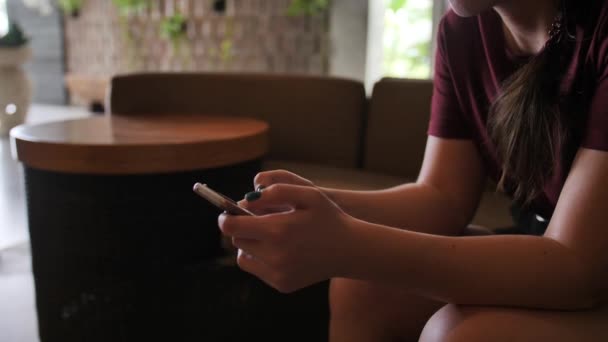 Uma jovem esperando por um quarto de hotel escreve em um bate-papo em um telefone celular — Vídeo de Stock