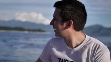 Genç adam tropik adaya bir transfer için bir sürat teknesinde oturuyor