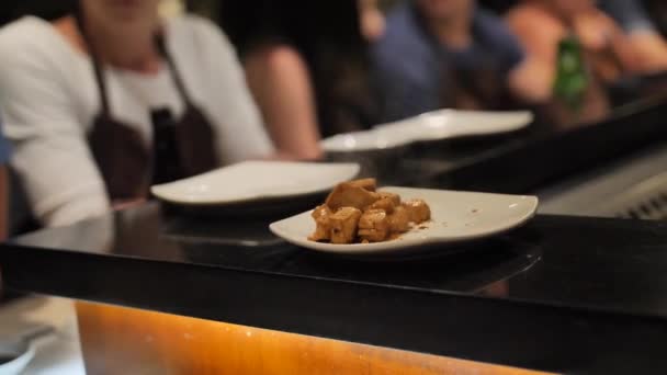 Повар кладет кусочки жареной курицы клиенту в тарелку — стоковое видео