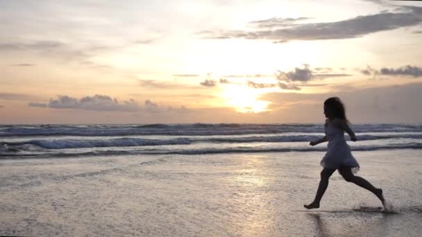 Silhouette eines schönen Mädchens, das entlang der Meeresküste läuft. — Stockvideo