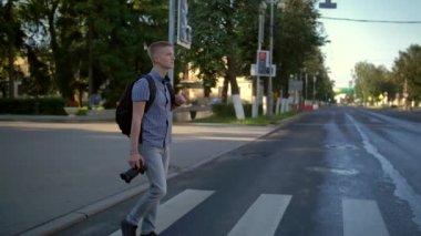 Kamerası olan adam yaya geçidinden geçiyor..