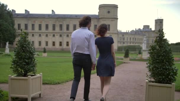 Um jovem casal caminha no parque . — Vídeo de Stock