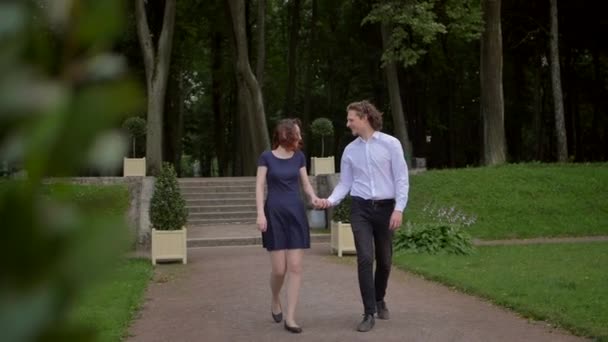 Een jong koppel wandelend in het park. — Stockvideo