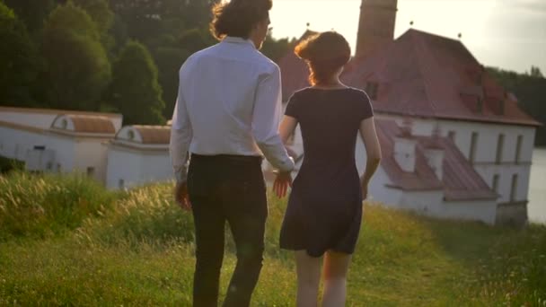 Vue arrière de jeunes couples amoureux promenades avec le palais du prieuré de Gatchina bg . — Video