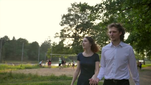 Ritratto frontale di giovane coppia, uomo e donna, che si tiene per mano camminando lungo un sentiero in una foresta . — Video Stock