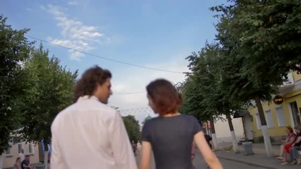 Una joven pareja camina por una calle peatonal de una ciudad europea — Vídeo de stock