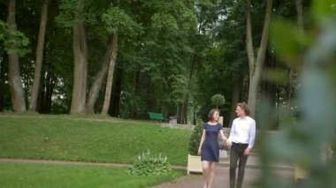 Genç bir çift parkta yürüyor.