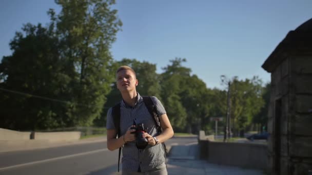 Egy turista áll az út közelében, és keresi a jó kameraállások meghozatalának nagy lövés — Stock videók