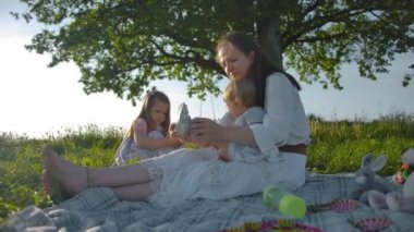 Genç anne, bir yaşındaki küçük kızına sandalet takıyor..