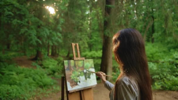 Blackhair woman paints a landscape oil painting in park — Stock Video