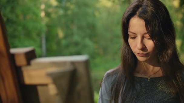 Portret weergave van een jong vrouwelijk schilderij landschap op doek in het Park — Stockvideo