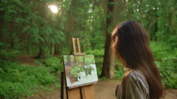 Young woman paints a landscape with oil painting in park — Stock Video