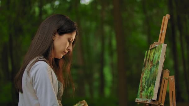 Esquema de retrato medio de una niña pintando un paisaje en un bosque — Vídeo de stock