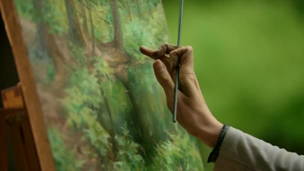 Close-up de uma palma de meninas com um pincel fazendo os toques borrados sobre sua pintura . — Vídeo de Stock