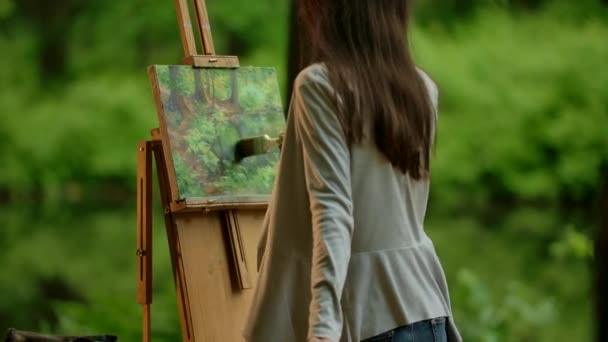 Attractive slender caucasian brunette girl drawing a picture — Stock Video
