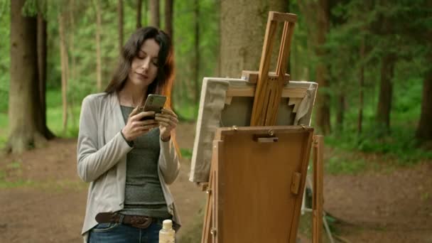 Frente quadro médio da artista menina com telefone celular em um parque . — Vídeo de Stock