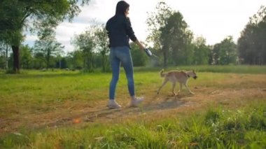Köpeğiyle birlikte parkta çekilmiş geniş bir kadın fotoğrafı..