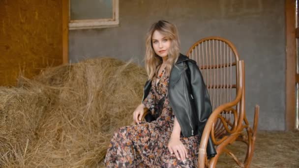 Chica atractiva balanceándose en una mecedora en una granja . — Vídeos de Stock