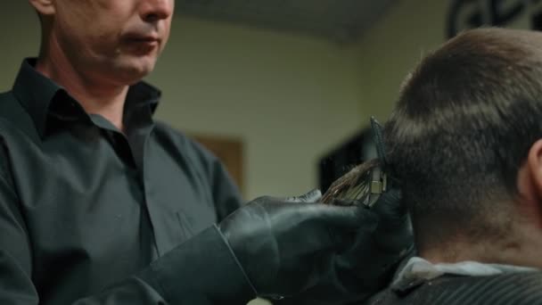 Gros plan de coiffeur faisant coupe de cheveux avec tondeuse au client — Video