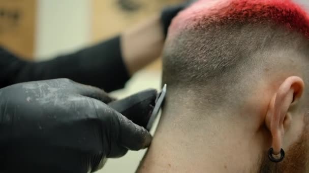 Κοπή μαλλιών με trimmer στο κεφάλι του πελάτη με ροζ μαλλιά — Αρχείο Βίντεο