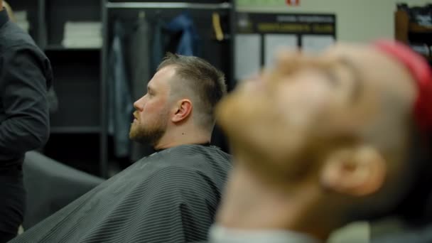 Focusing the camera from one hairdresser client to another. — Stock Video